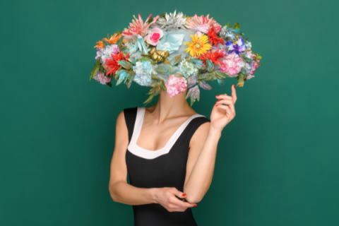 woman in dress and large hat covered in flowers 