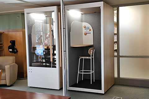 Photo of two phone booths, one with its door open.