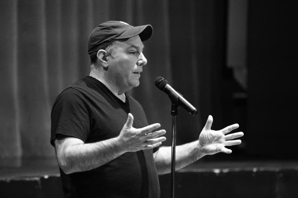 Black and white image of Matthew Dicks speaking at microphone