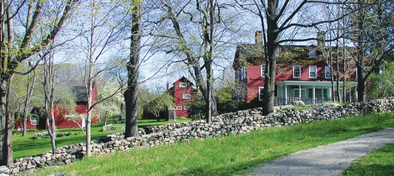 Weir House and Studios surrounded by trees and a lush lawn. 