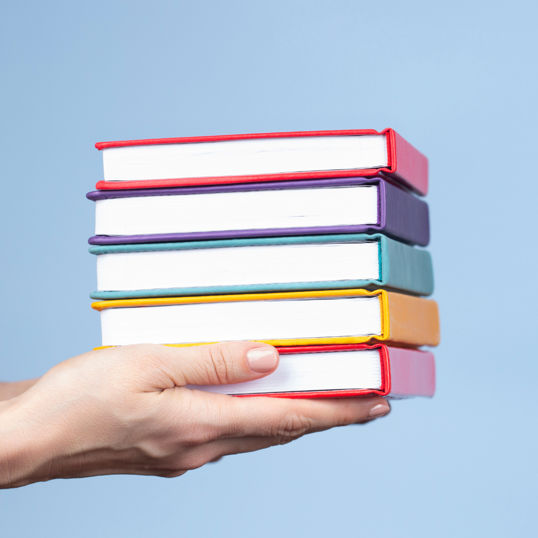 Hands carrying a stack of books