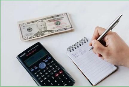 image of a calculator, notepad and money