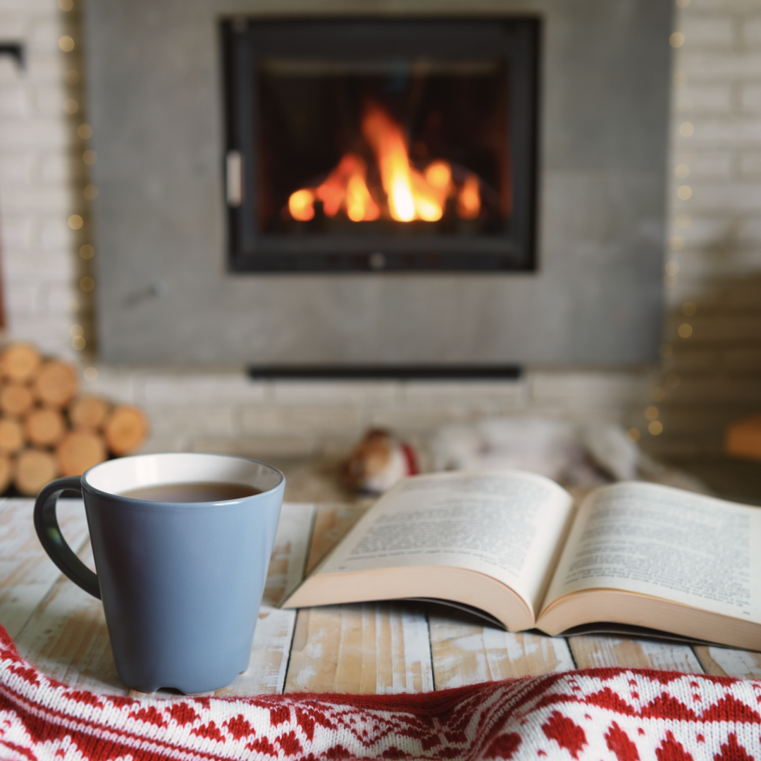 mug and book in front of fireplace